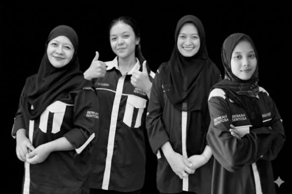 Four women in matching black and white uniforms stand side by side, smiling; two show thumbs up, indicating a friendly team photo.